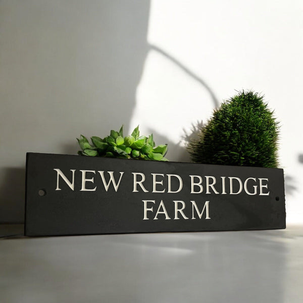 Introducing our stunning 40cm x 10cm Polished Natural Slate House Sign, designed to make a lasting impression! Crafted with durability in mind, it features beautifully carved lettering that enhances its elegance and visibility. Transform your home's entrance with this exquisite sign! www.HouseSign.co.uk